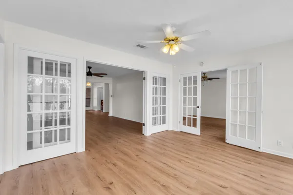 a view of an empty room with a window and wooden floor