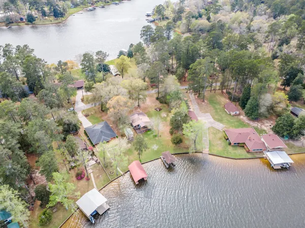 an aerial view of a house with a yard and lake view