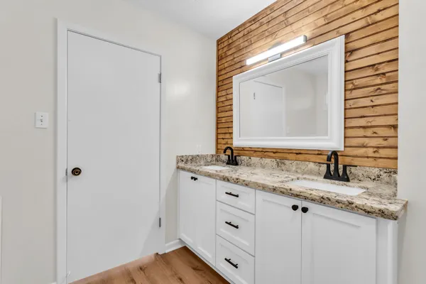 a bathroom with a granite countertop sink and a mirror