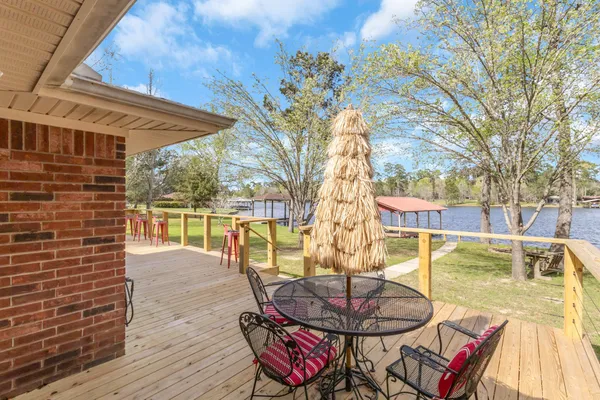 a view of a patio with table and chairs potted plants and large tree
