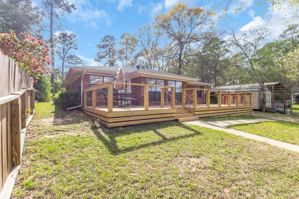 a view of a house with a wooden deck and a backyard
