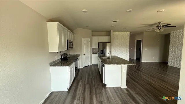 a kitchen with a sink and wooden floor