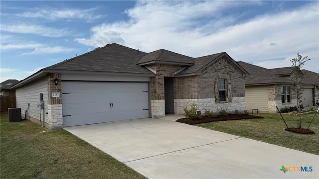 a kitchen with granite countertop a stove a sink dishwasher a refrigerator and a microwave oven with wooden floor