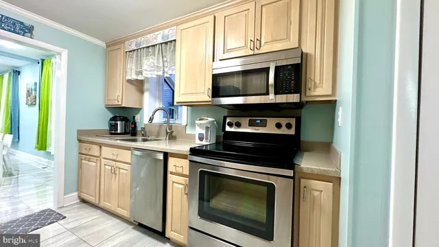 a kitchen with stainless steel appliances granite countertop a sink and a refrigerator
