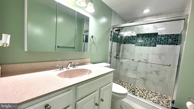 a bathroom with a sink a toilet and shower