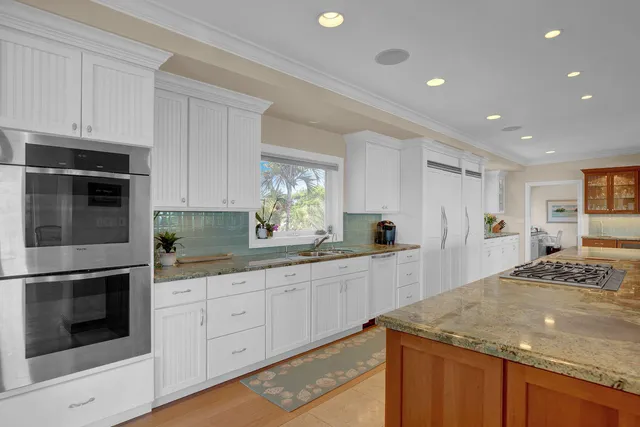 a kitchen with granite countertop kitchen island white cabinets and wooden floor