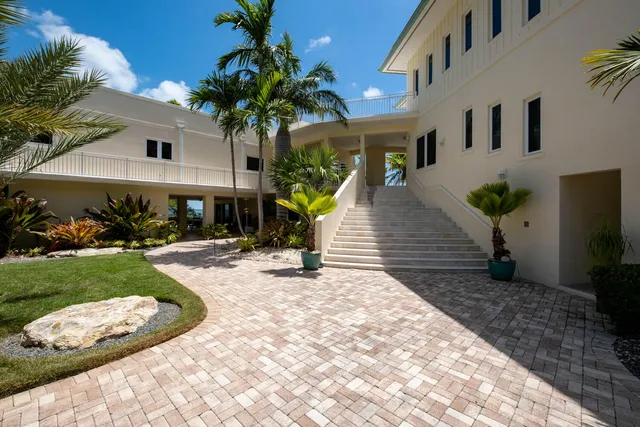 a view of a house with a yard and potted plants