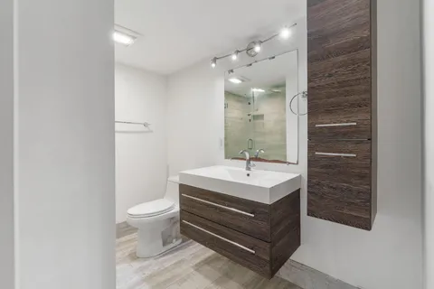 a bathroom with a sink a toilet and a mirror