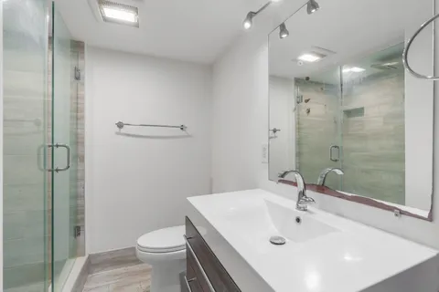 a bathroom with a sink a toilet and shower