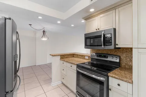 a kitchen with granite countertop a stove sink and microwave