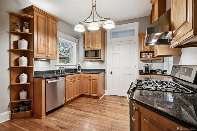 a kitchen with stainless steel appliances granite countertop a sink stove and cabinets