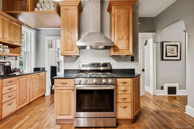 a kitchen with stainless steel appliances a stove and white cabinets
