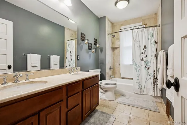 a spacious bathroom with a double vanity sink toilet mirror and shower