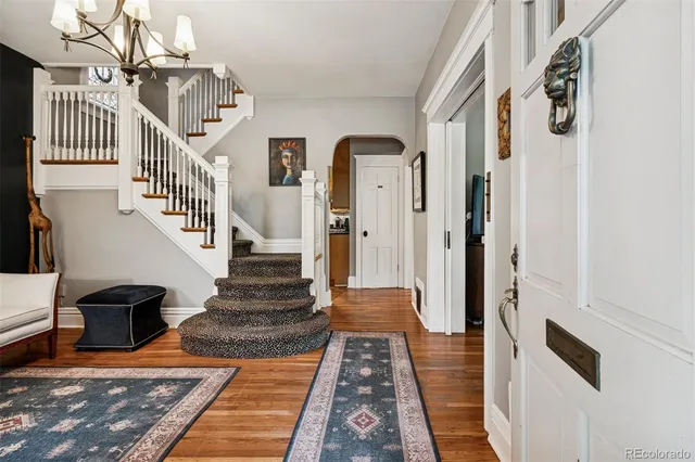 a view of a hallway with wooden floor and staircase