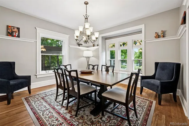 a view of a dining room with furniture a rug and wooden floor