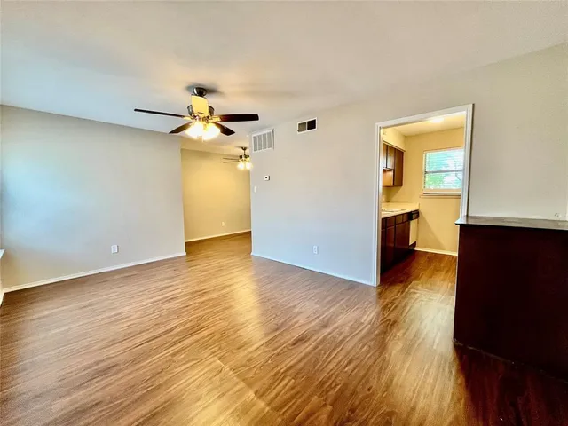 a view of a kitchen with wooden floor and a ceiling fan