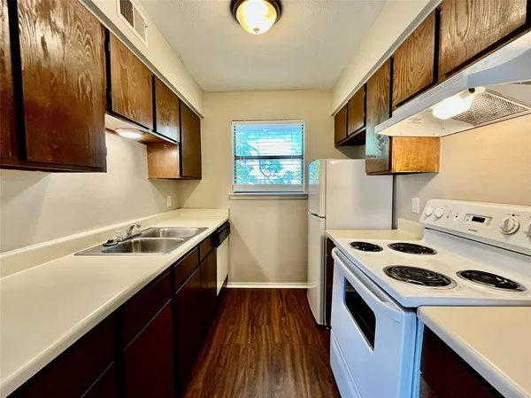 a kitchen with a sink a stove and a refrigerator