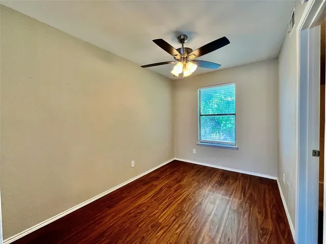 an empty room with wooden floor and a window