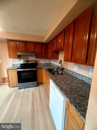 a kitchen with stainless steel appliances granite countertop a stove a sink dishwasher and a microwave oven with cabinets