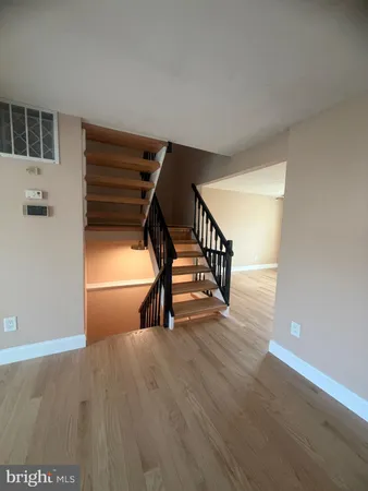 a view of an empty room with stairs and a window