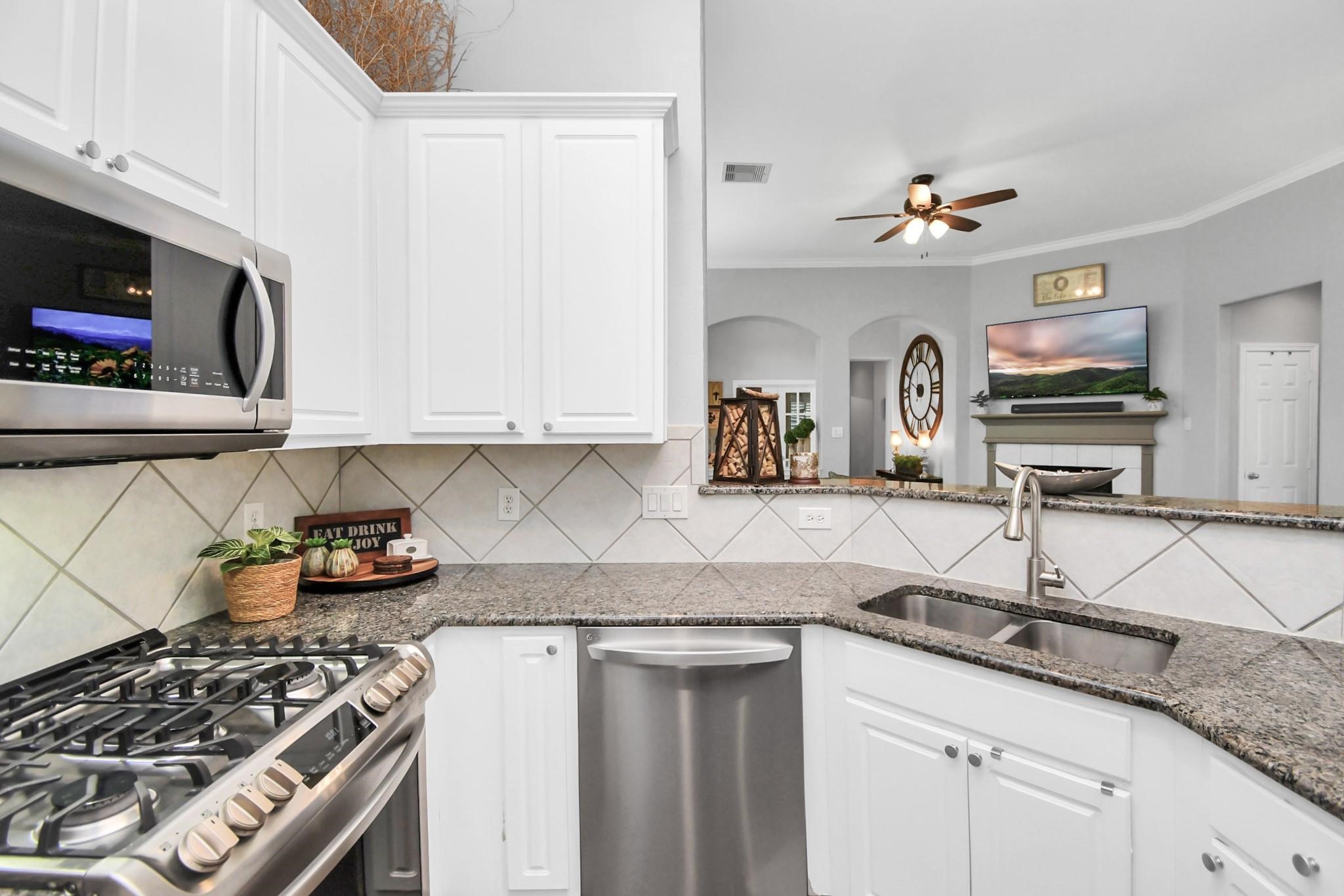 8624 Sunset Loch Drive Spring, TX 77379 - Photo 14 of 44 a kitchen with stainless steel appliances granite countertop a sink stove and cabinets
