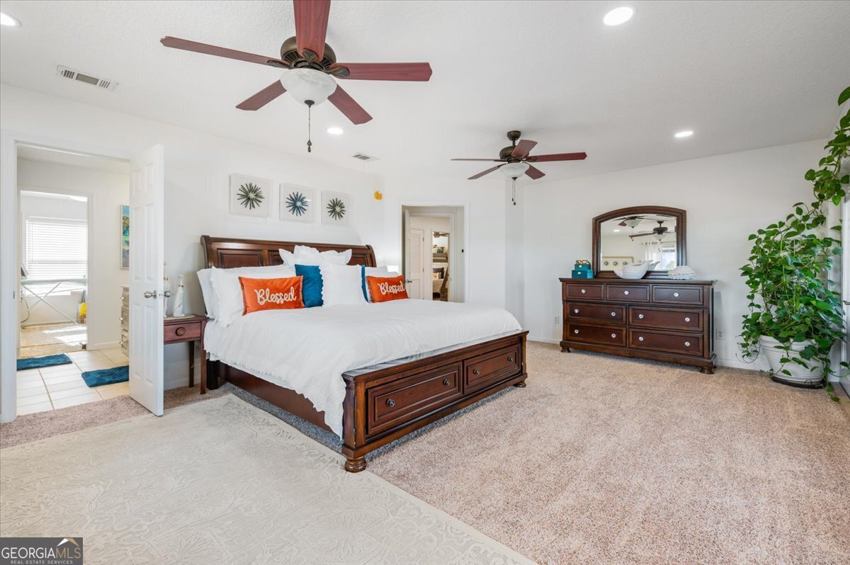 201 Miles Road Bristol, GA 31518 - Photo 24 of 69 a spacious bedroom with a bed and a chandelier