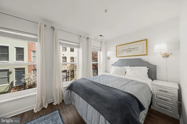 a bedroom with a large bed and wooden floor