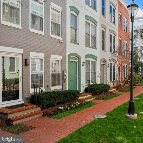 a front view of a multi story building with yard and green space