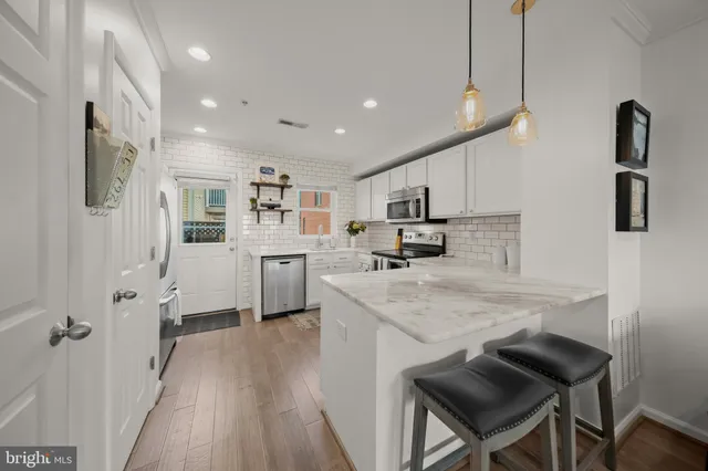 a kitchen with cabinets and wooden floor