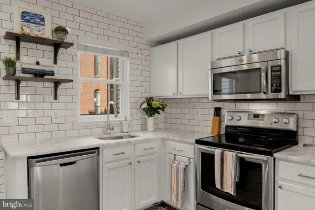 a kitchen with stainless steel appliances a stove sink microwave and cabinets