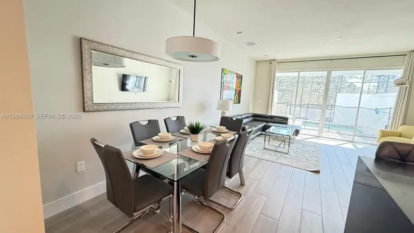 a view of a dining room with furniture a chandelier and wooden floor