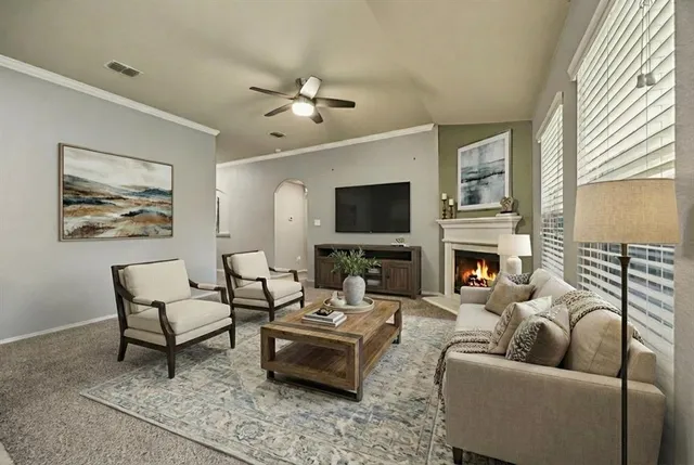 a living room with furniture a fireplace and a flat screen tv