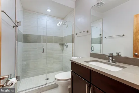 a bathroom with a double vanity sink toilet and shower