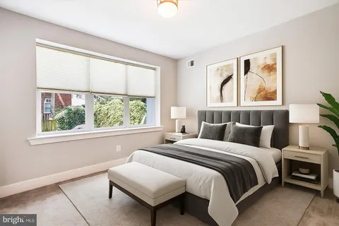 a bedroom with bed and a large window