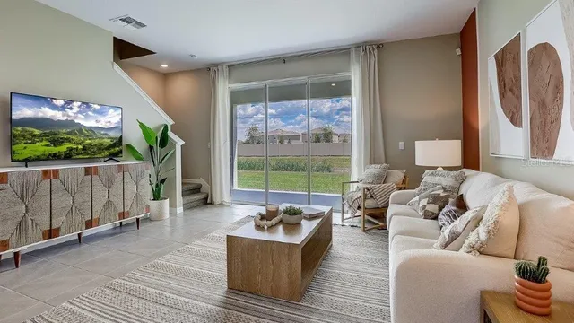 a living room with furniture a rug and kitchen view