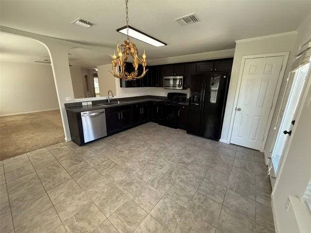 a kitchen with granite countertop a refrigerator and a sink