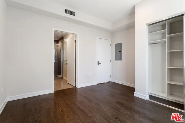 an empty room with wooden floor and closet