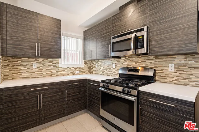 a kitchen with stainless steel appliances granite countertop wooden cabinets and a stove top oven