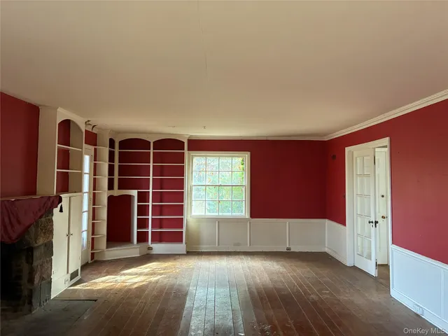 a view of an empty room with a fireplace and a window