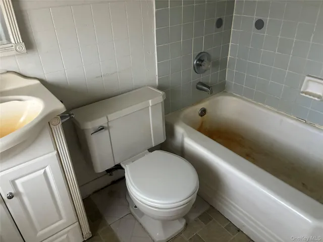 a white toilet sitting next to a bath tub