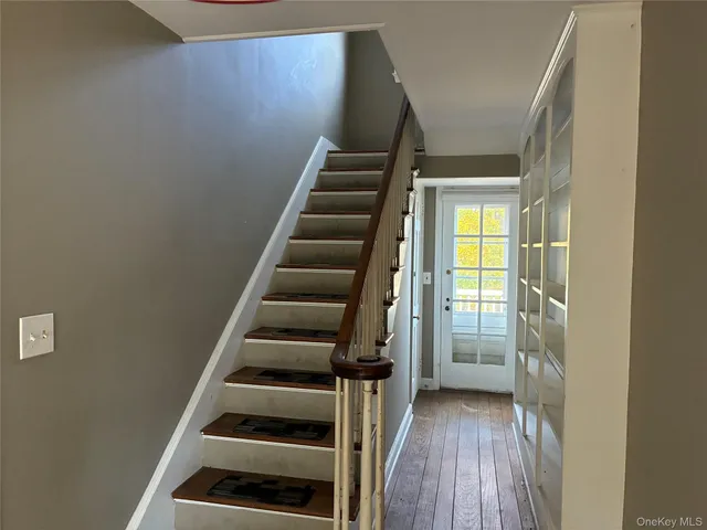a view of an entryway with wooden floor and staircase