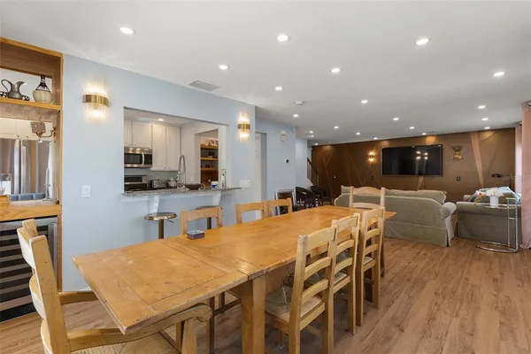 a dining room with furniture a large window and wooden floor