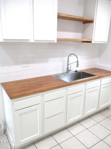 a kitchen with white cabinets sink and dishwasher