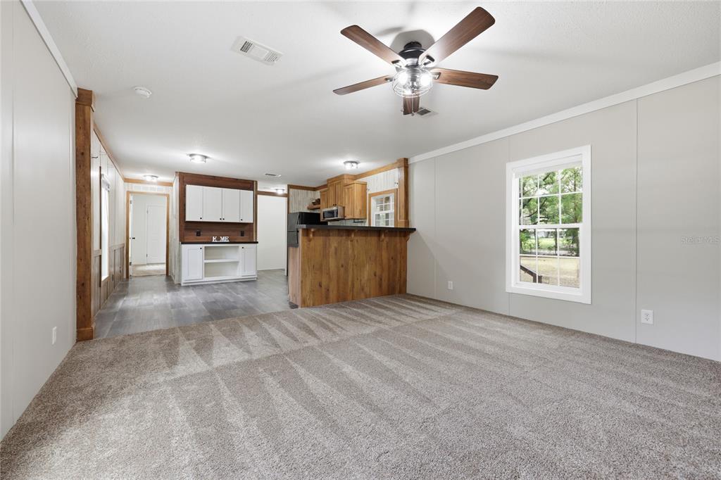215 Southwest Alpine Place High Springs, FL 32643 - Photo 10 of 41 a view of a kitchen with a stove cabinets a ceiling fan and wooden floor