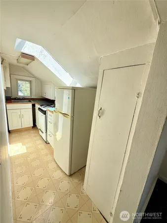 a kitchen with a refrigerator a stove top oven and a cabinets