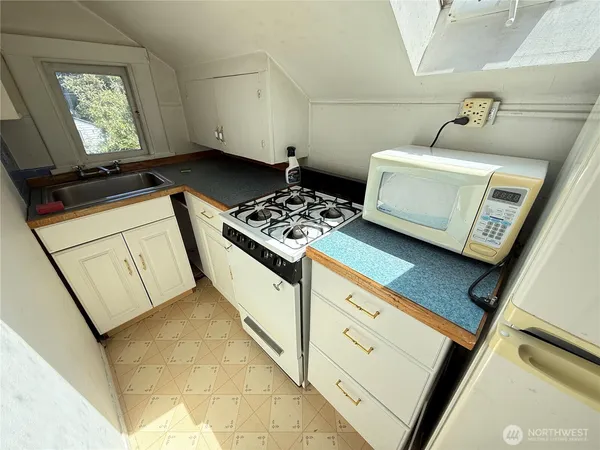 a kitchen with a stove a sink and a counter top space