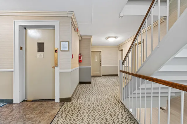 a view of a hallway with wooden floor and stairs