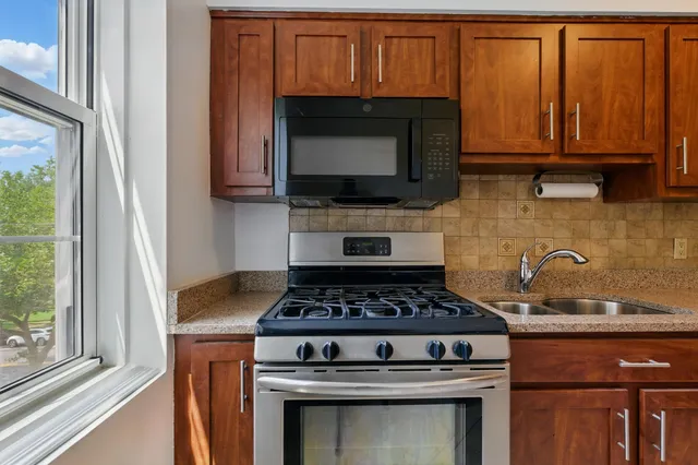 a kitchen with granite countertop a stove and a microwave
