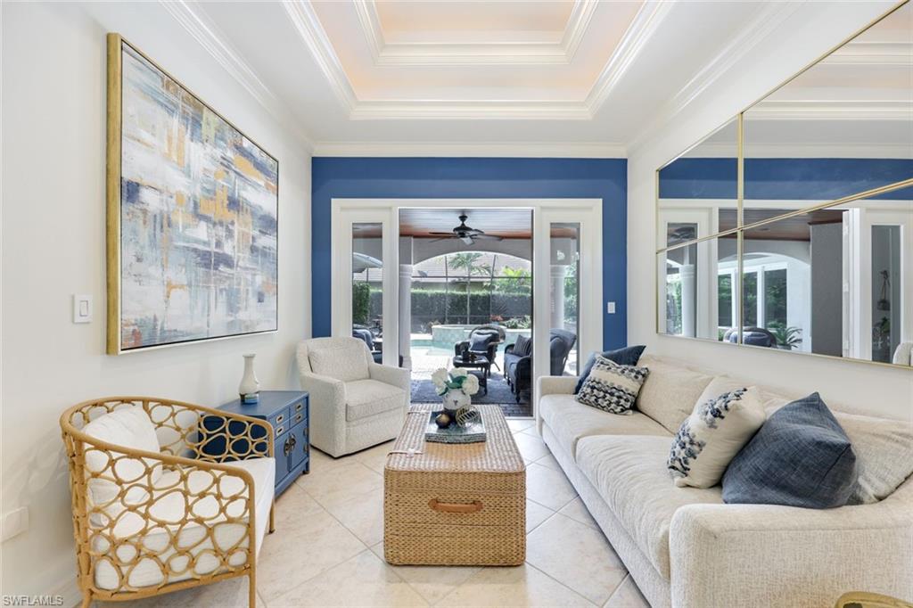 3960 Deep Passage Way Naples, FL 34109 - Photo 11 of 34 Well-appointed living room featuring attractive tile flooring, tray ceilings, crown molding, and charming French doors that offer a delightful connection to the outdoors.
