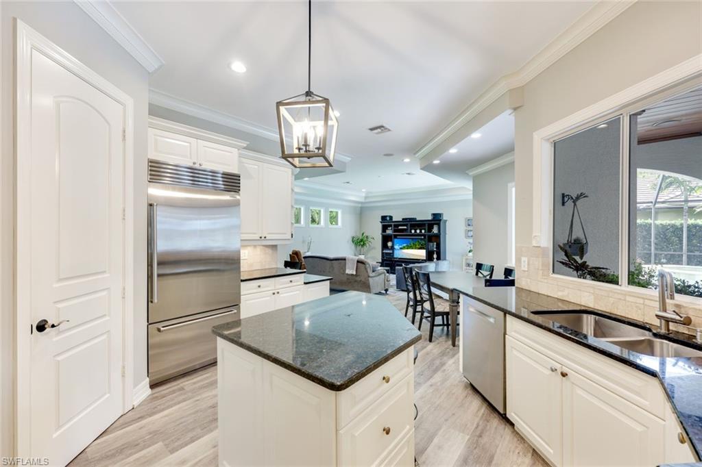 3960 Deep Passage Way Naples, FL 34109 - Photo 12 of 34 Well-appointed kitchen featuring a Sub-Zero refrigerator, an array of stainless steel appliances, granite countertops, crown molding and stylish hanging light fixtures.
